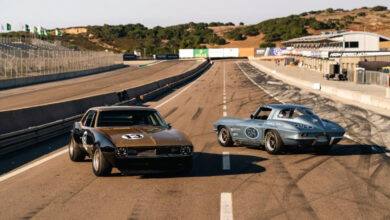 Two classic race cars parked on track
