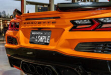 A sample version of the approved design for LeMay – America's Car Museum's custom license plate on an orange C8 Corvette.