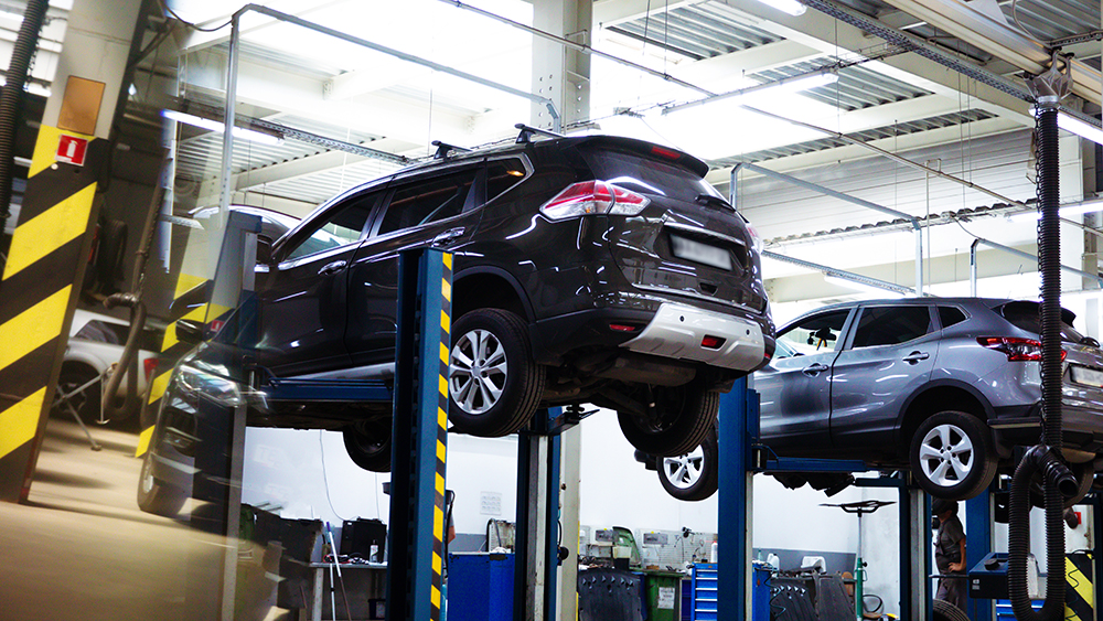 Modern car repair station with vehicles on lifts