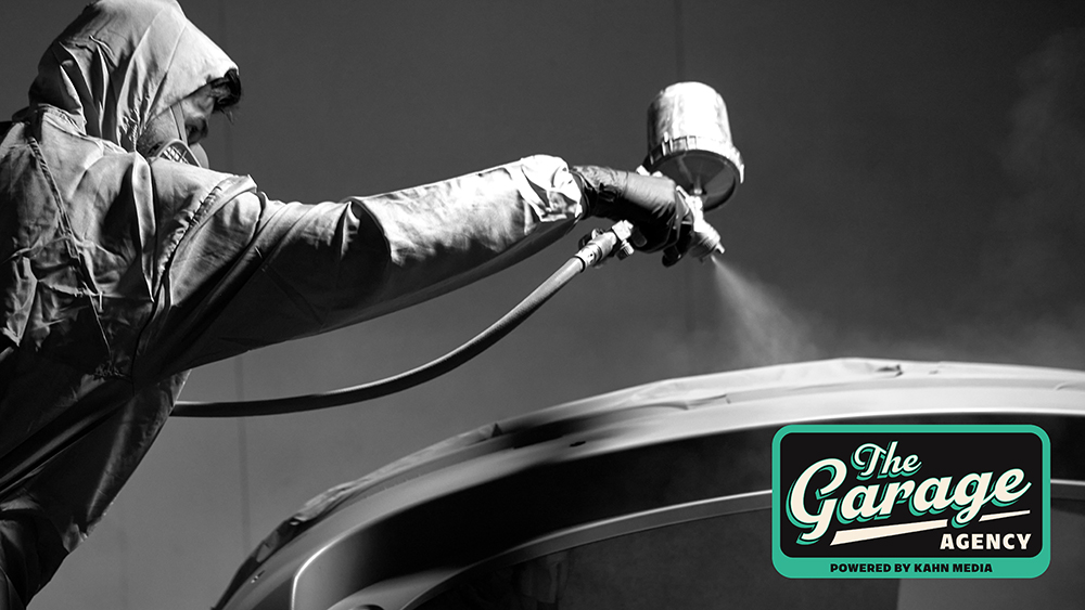 Person spray painting roof of car