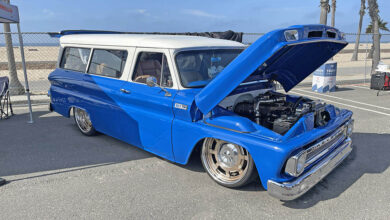 A blue custom 1965 Chevy Suburban with open hood revealing engine