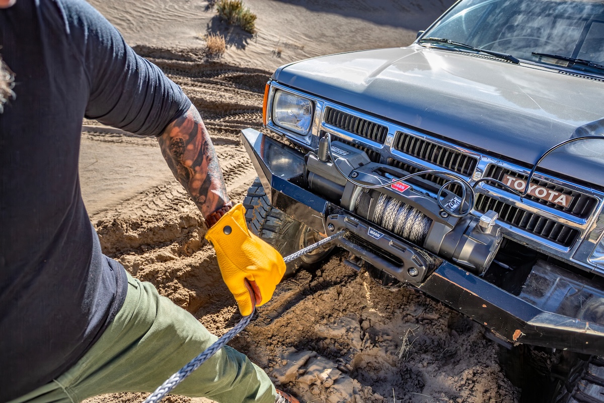 winches warn silver toyota front mount uphill gloved hands on line