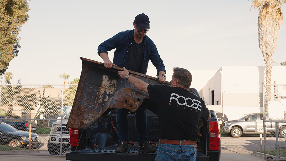 Ben Johnson handing Chip Foose parts of his burnt Delay from truck bed