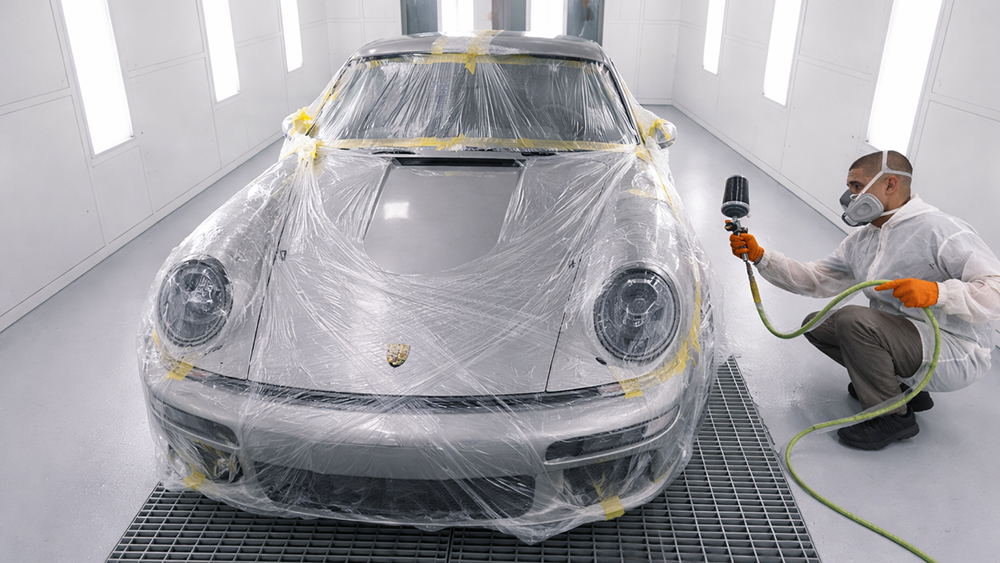 Person prepping Porsche 911 for painting