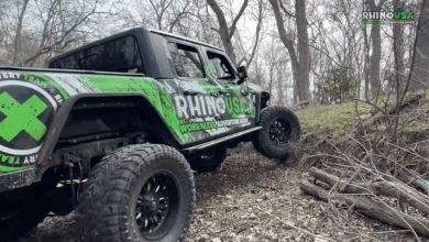 Rhino USA branded truck driving up hill in woods