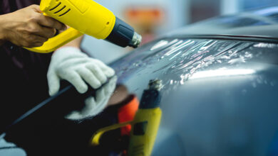 Technician uses equipment to install car window film.