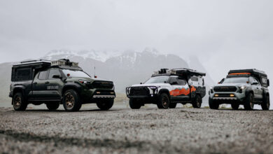 Three XOVERLANDs parked on gravel road in front of snowy mountain