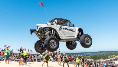 turn 14 utv takeover side-by-side flies over jump on sandy beach as fans watch