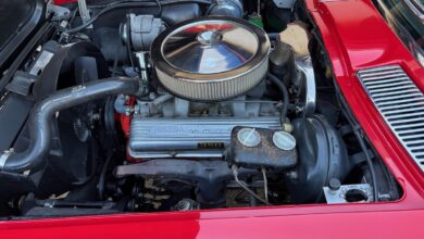 carb restoration in a red corvette with hood up
