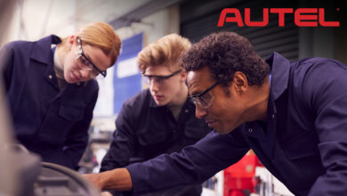 Auto mechanic teacher and students looking at engine