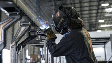 Auto tech welding chassis in garage