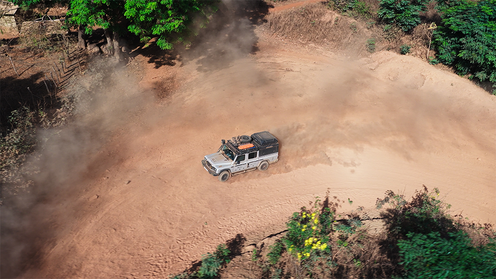 Day 13 - Aerial shot of the Ineos Grenadier on dirt road Guinea