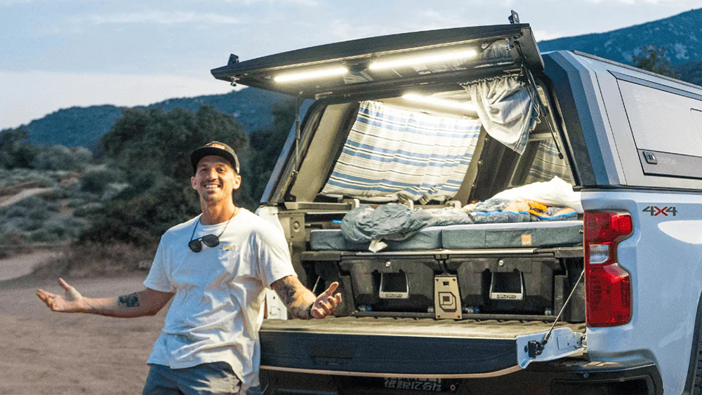 Man standing behind truck with lighting attached to camper door