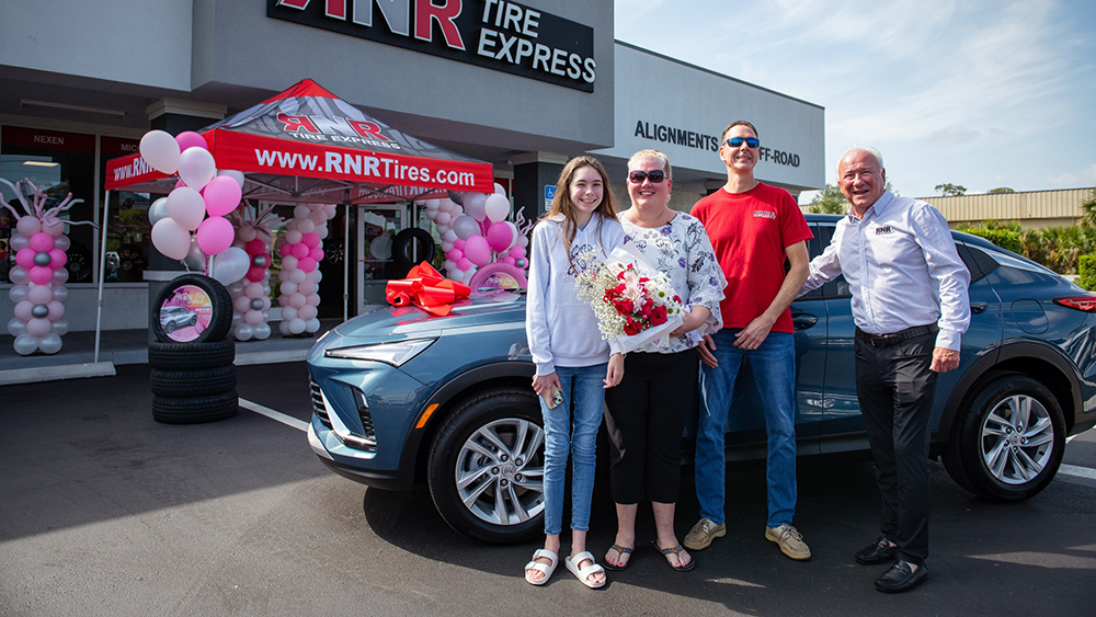 A 2025 Mother’s Day Car Giveaway recipient stands with her new Buick Envista