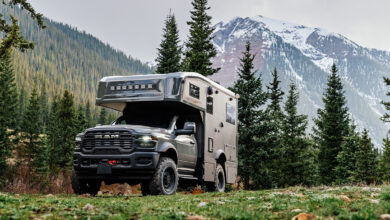 Storyteller Overland GXV WILD parked in front of trees and mountain