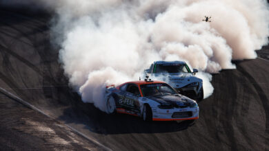 Two cars drifting on track with lots of smoke