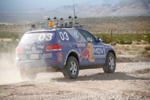 blue vw "stanley" autonomous vehicle operates on dirt road
