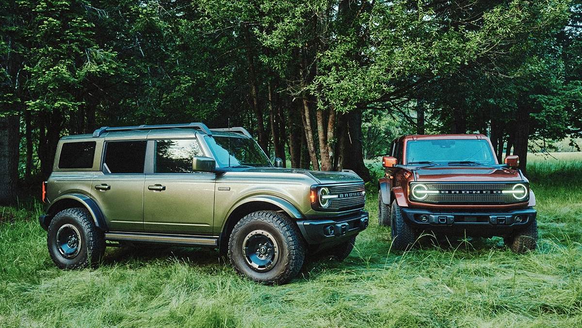 Two 2027 Bronco Filsons parked in grassy area in the woods