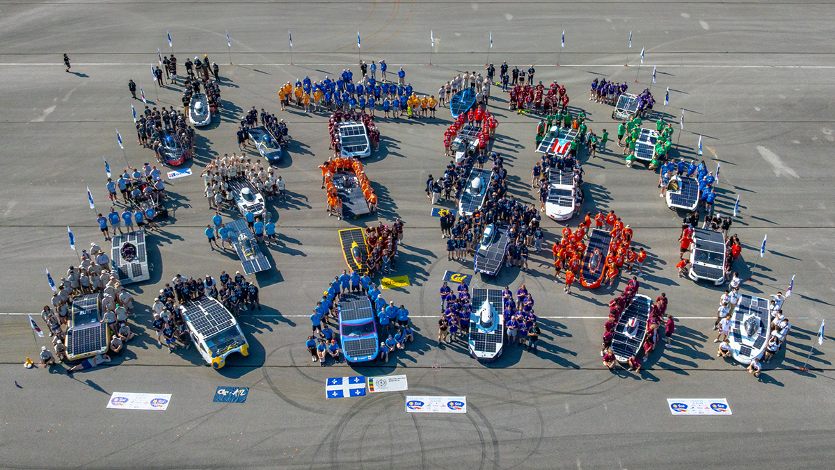 Aerial photo of collegiate solar car teams with national and team flags