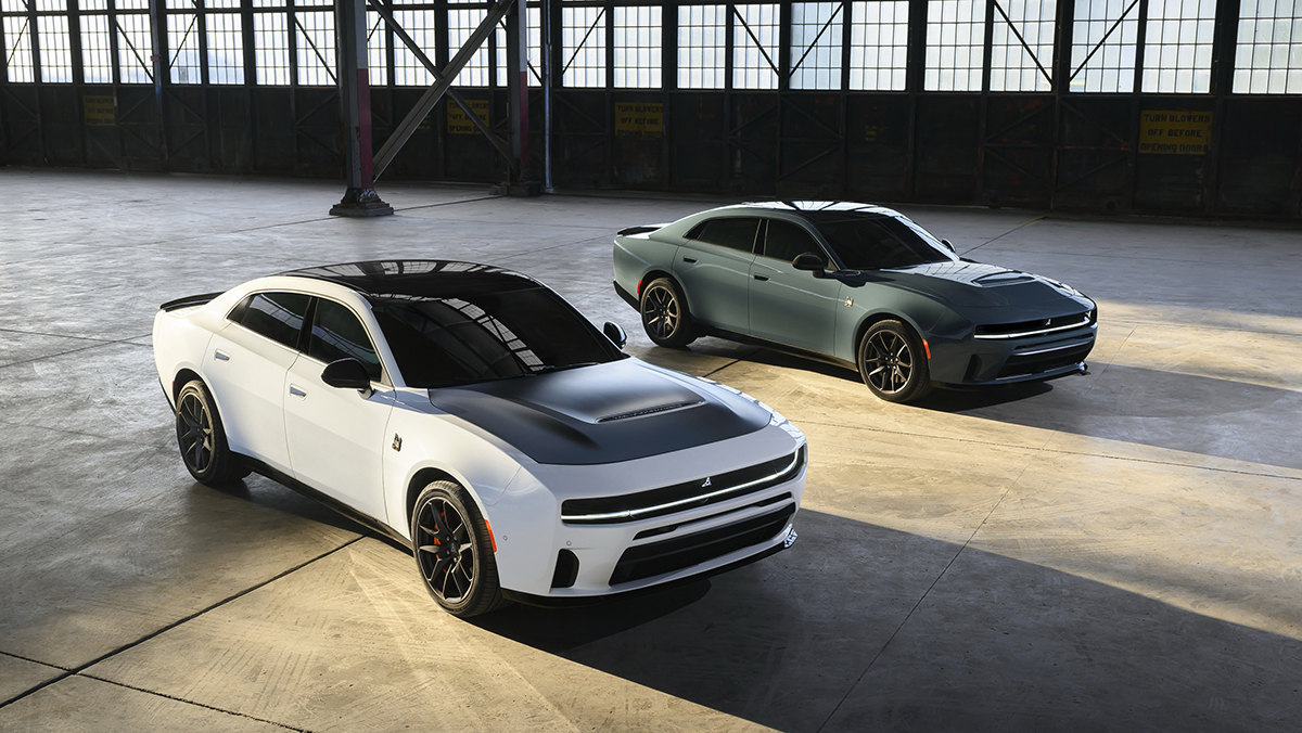 Gas-powered, 550-horsepower 2027 Dodge Charger Scat Pack models, shown in White Knuckle and Sub-Zero exterior colors parked in warehouse
