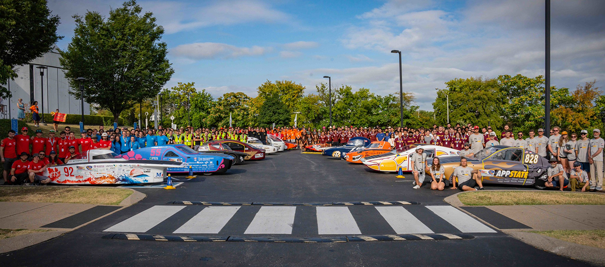 Teams line up with their solar cars for a group portrait