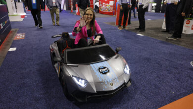 True Brand photo driving a mini car on AAPEX Show Floor