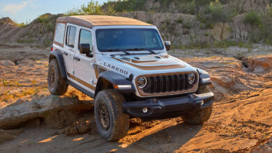 The 2027 Jeep Wrangler Laredo crawling over a rock on the trail.