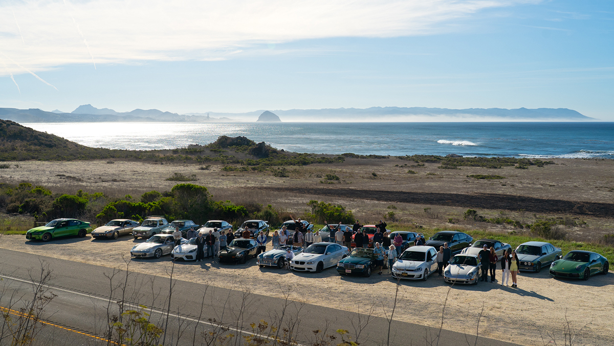 Participants from the 2025 Hemmings Motor Club Rally standing next to their cars
