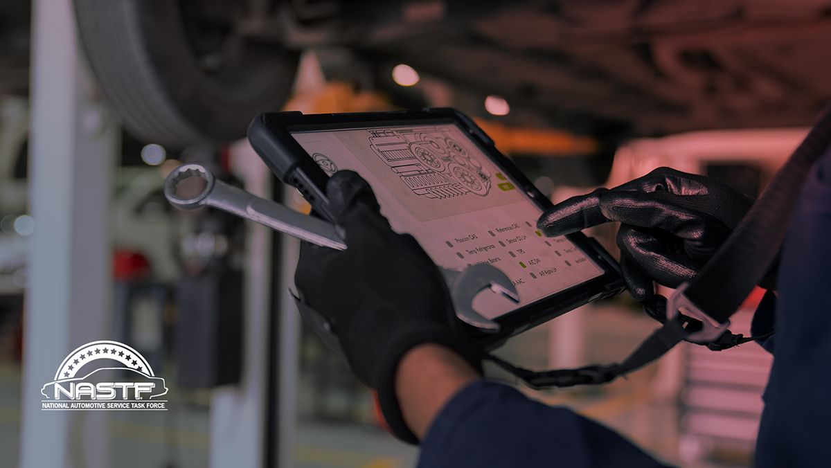 Auto technician examining data on tablet