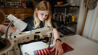 Morgan Moravec sews a car interior panel as part of a restoration school project