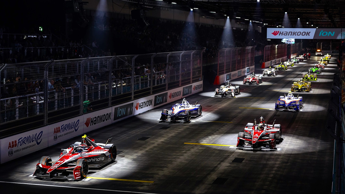 Formula E race cars on track at night