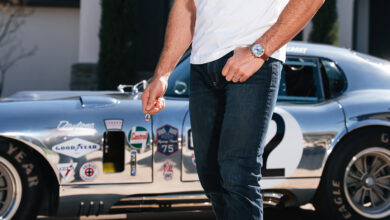 Bulova Shelby Watch 2026 on wrist of man in front of 50th Anniversary Aluminum Edition Daytona Coupe