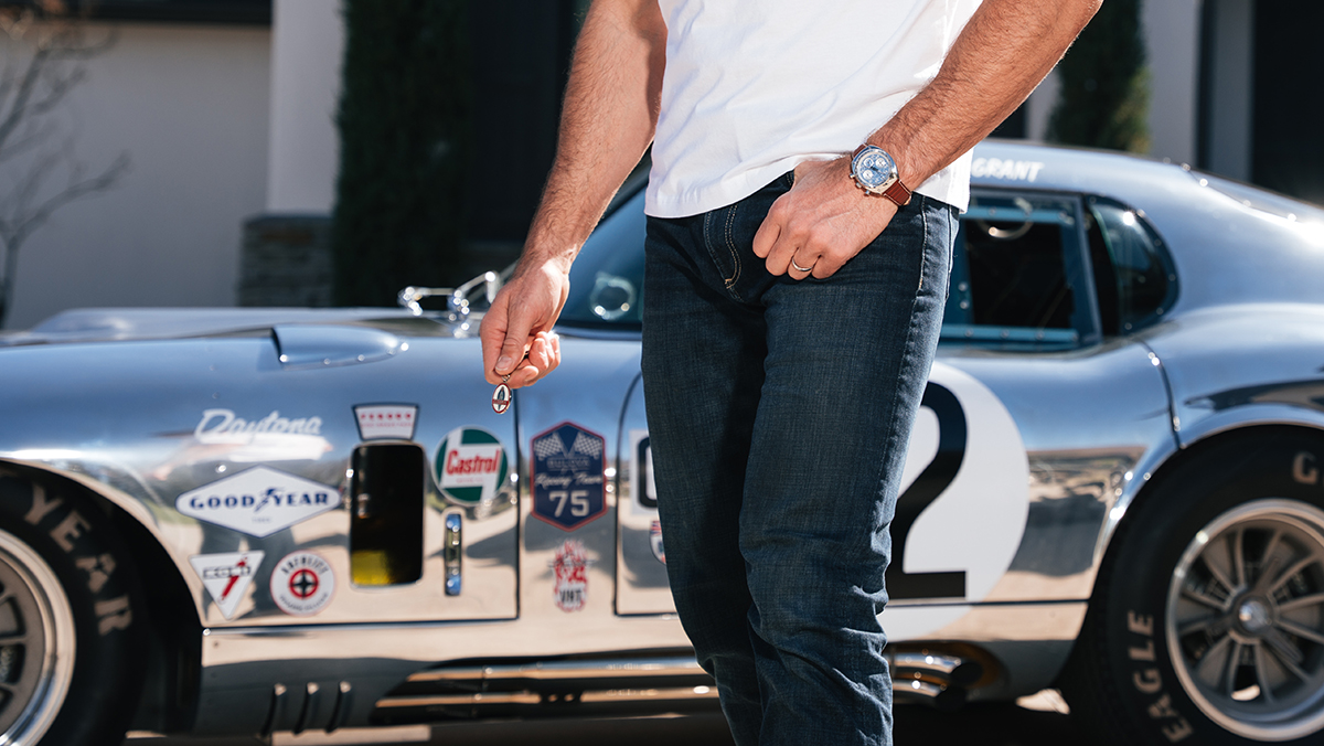 Bulova Shelby Watch 2026 on wrist of man in front of 50th Anniversary Aluminum Edition Daytona Coupe