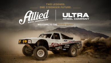 ALLIED nd ULTRA logos above truck kicking up sand