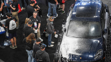 People taking turns spraying car at SEMA Show booth