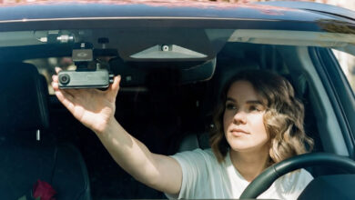 Woman adjusting dash cam from driver's seat
