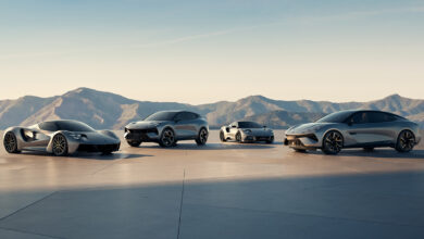 Group of Lotus vehicles with mountains in the background