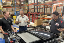 Host Jesse Stoddard & Bill North examine a sunroof assembly at Champion Auto Systems
