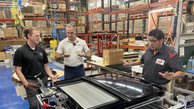Host Jesse Stoddard & Bill North examine a sunroof assembly at Champion Auto Systems