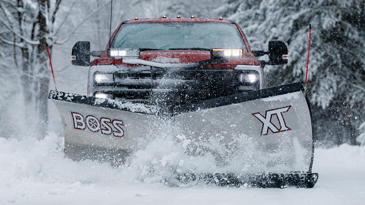 Truck with snowplow attached to the front driving through the snow