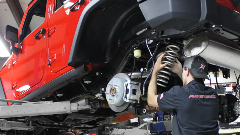 Auto tech working under Jeep
