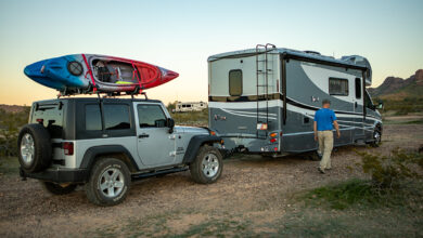 RV towing Jeep on dirt road