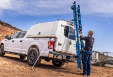Man removing ladder from top of utility truck