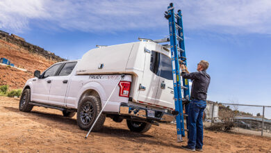 Man removing ladder from top of utility truck