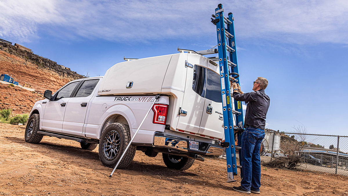 Man removing ladder from top of utility truck