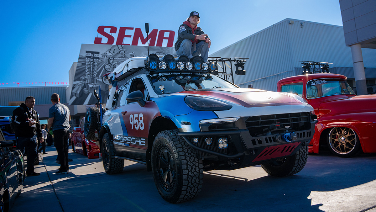 Houck at the 2024 SEMA Show sitting on the roof of a highly customized 2015 Porsche Cayenne Overlander