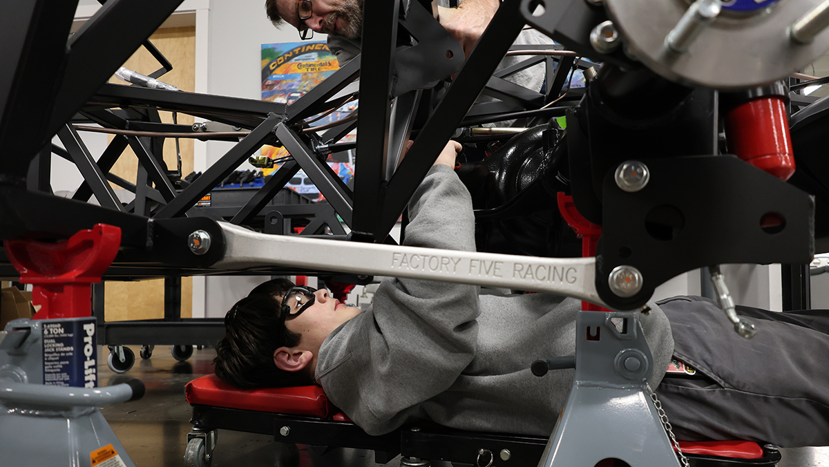 Young person working under car